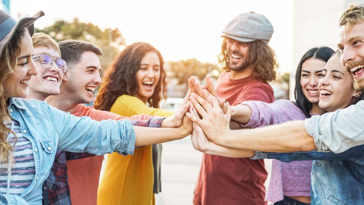 Eine Gruppe von jungen Menschen die alle gemeinsam einschlagen